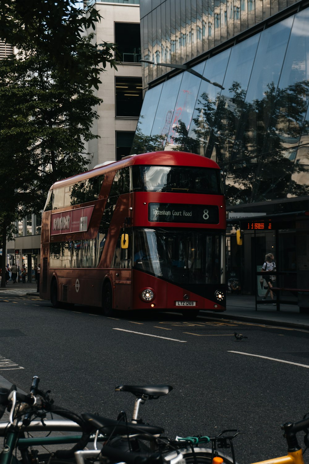 a red double decker bus driving down a street