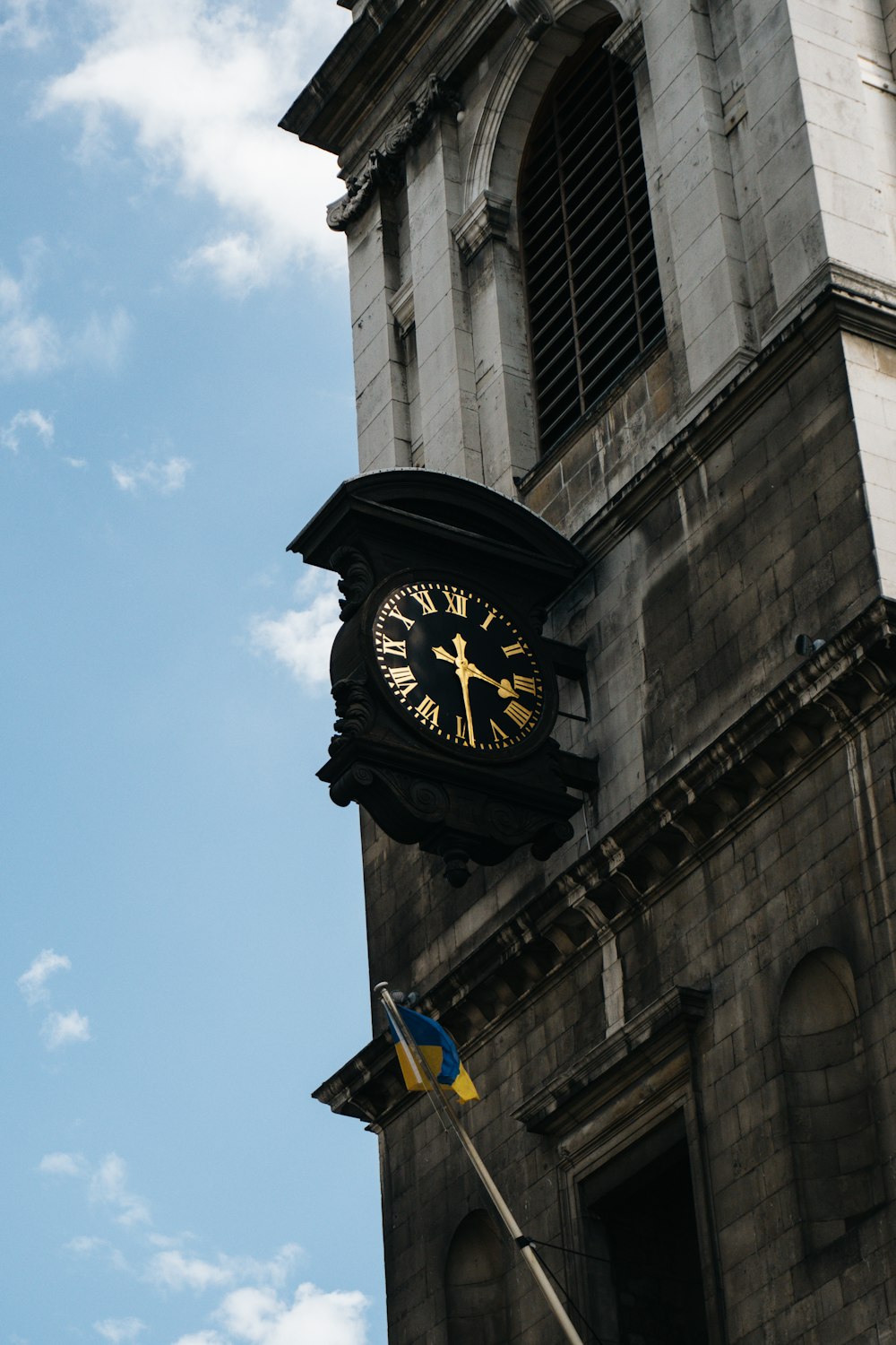 a clock on the side of a building with a sky background