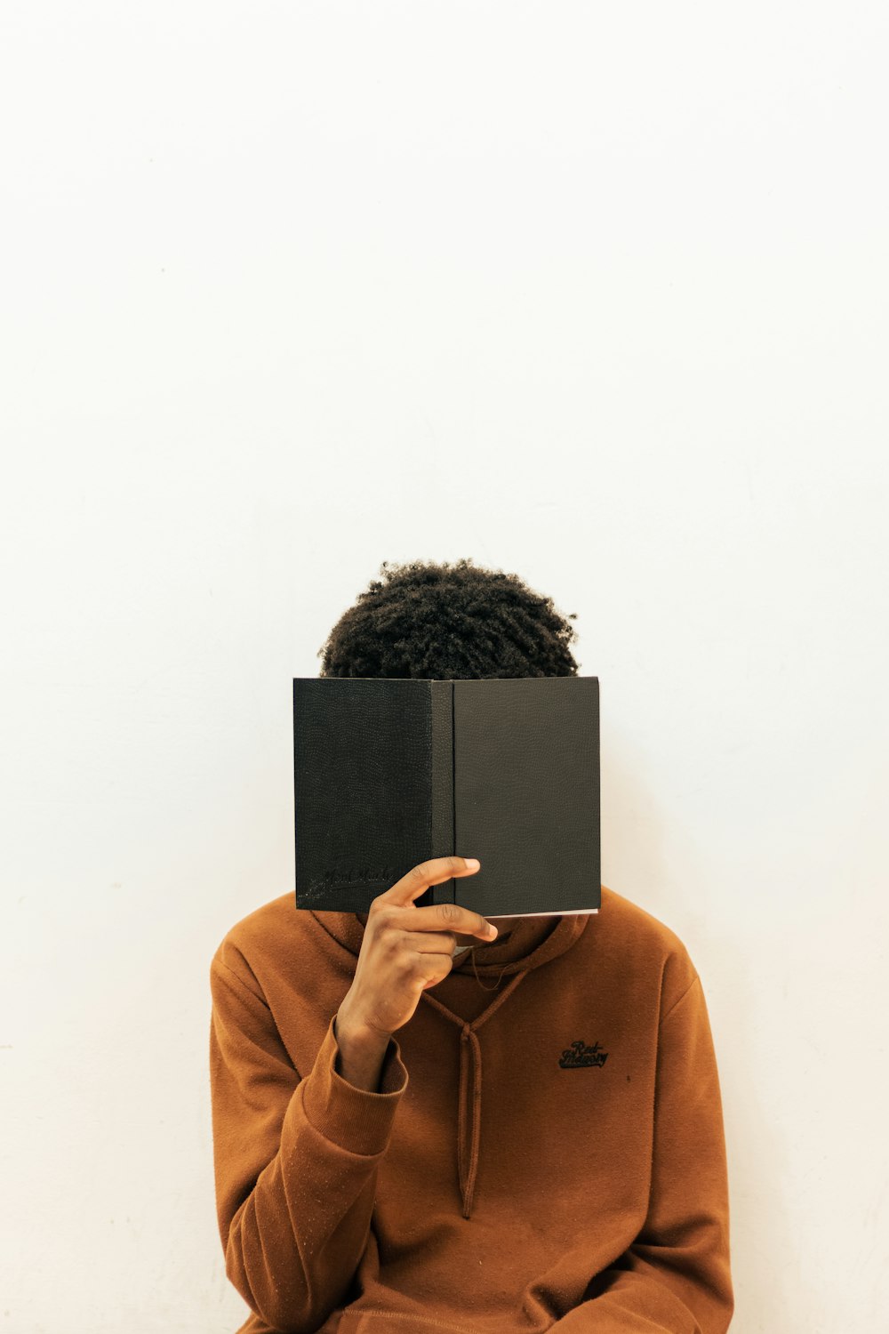 a person with a book covering their face