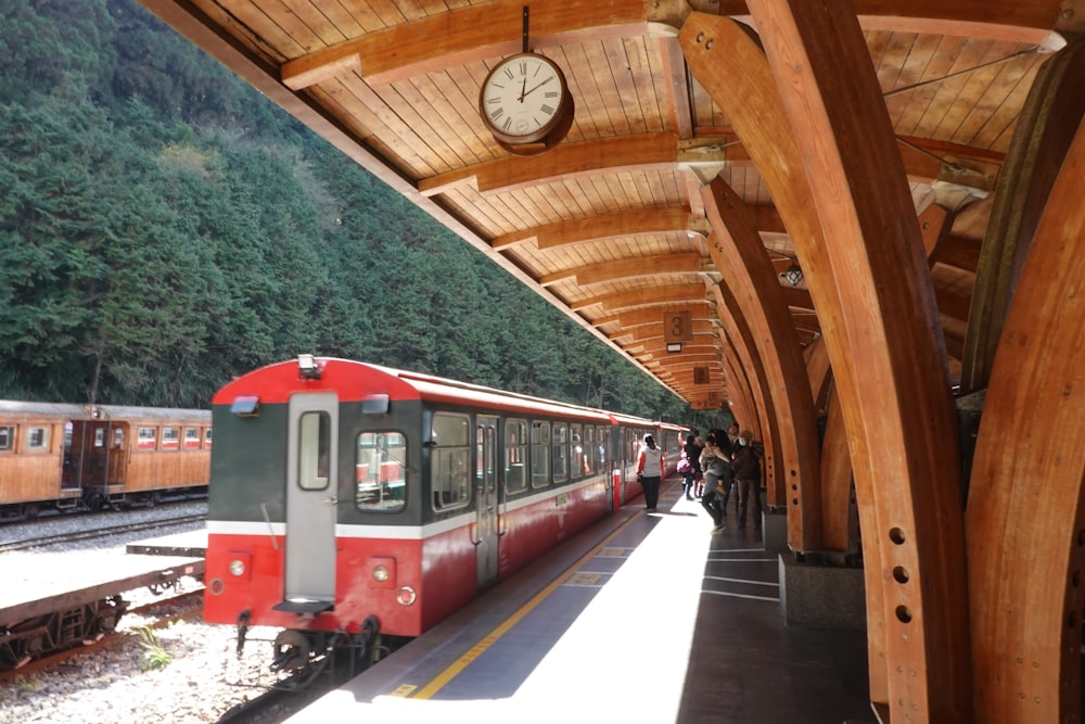 a red and white train pulling into a train station