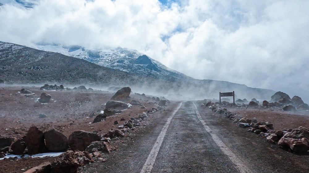 a dirt road with a sign on the side of it