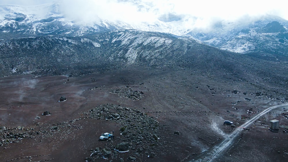 an aerial view of a mountain range with snow on the top
