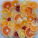 Bright citrus fruits arranged artistically next to a laptop displaying branding visuals.