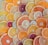 A vibrant assortment of sliced citrus fruits, including oranges, lemons, limes, and grapefruits, arranged in an overlapping pattern. The slices display a variety of colors from deep red to bright yellow and green, showcasing the diverse textures and juices of the fruits.