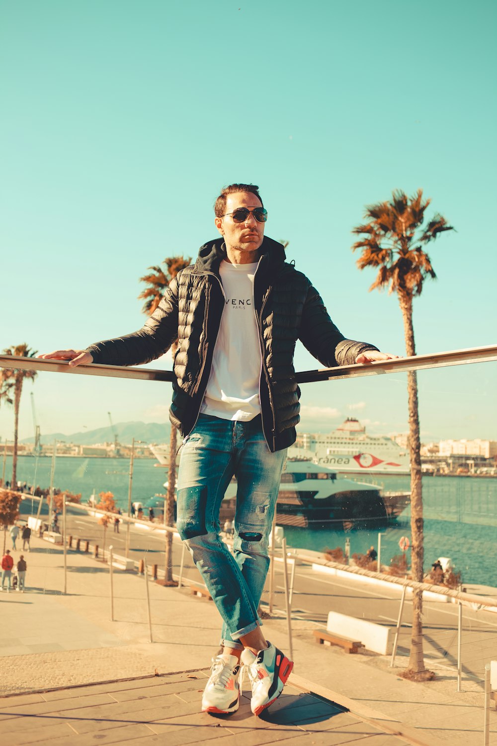 a man standing on a rail near a body of water