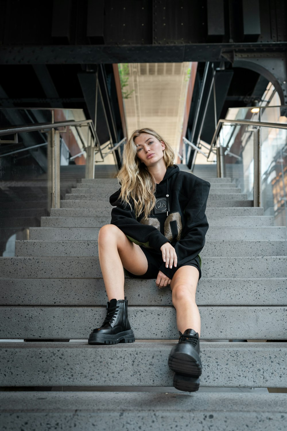 a woman sitting on some steps with her legs crossed