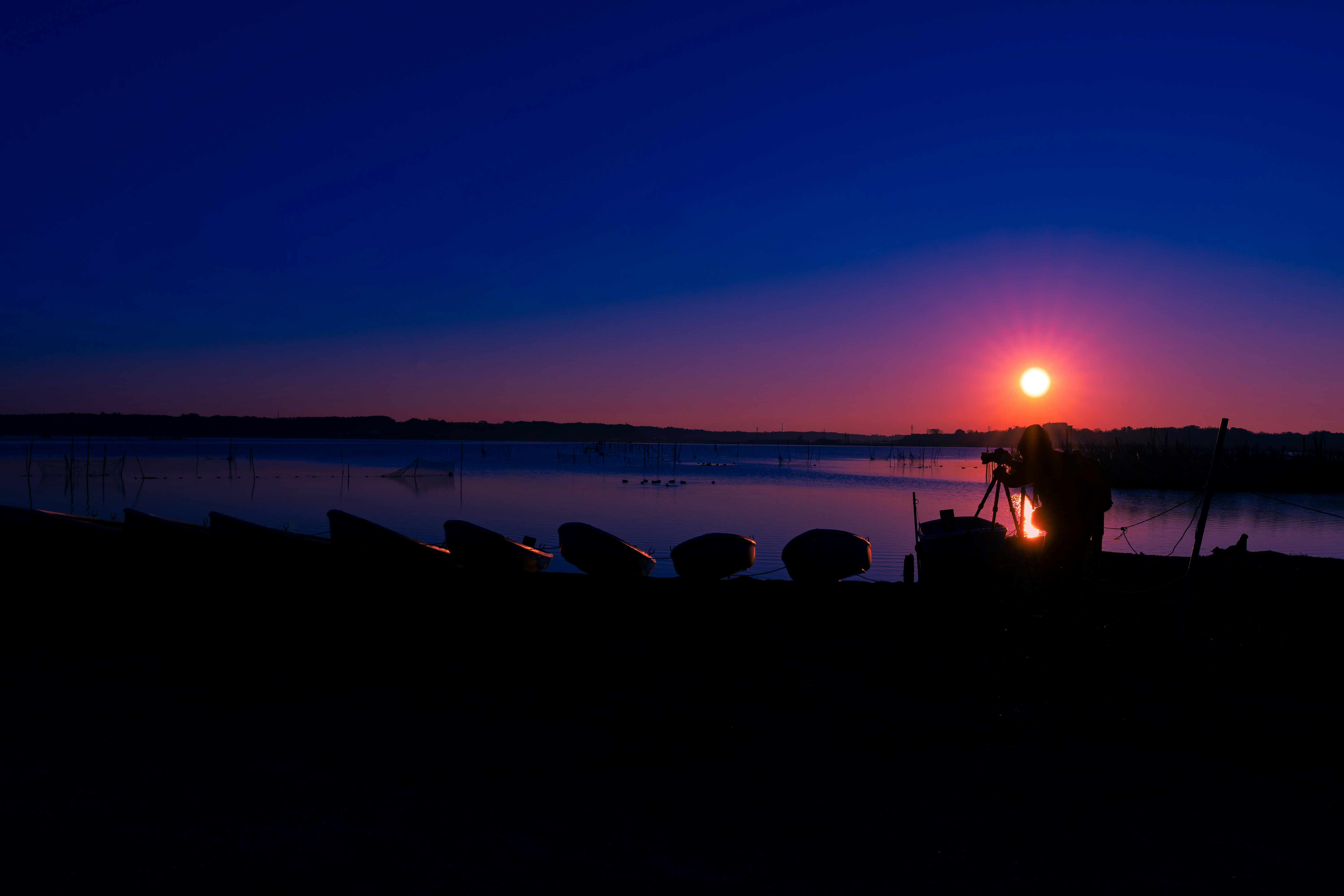 the sun is setting over a body of water