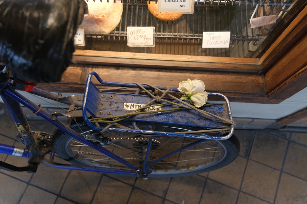 a blue bicycle with a flower on the back of it