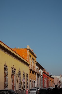 a row of buildings with cars parked on the side of the street