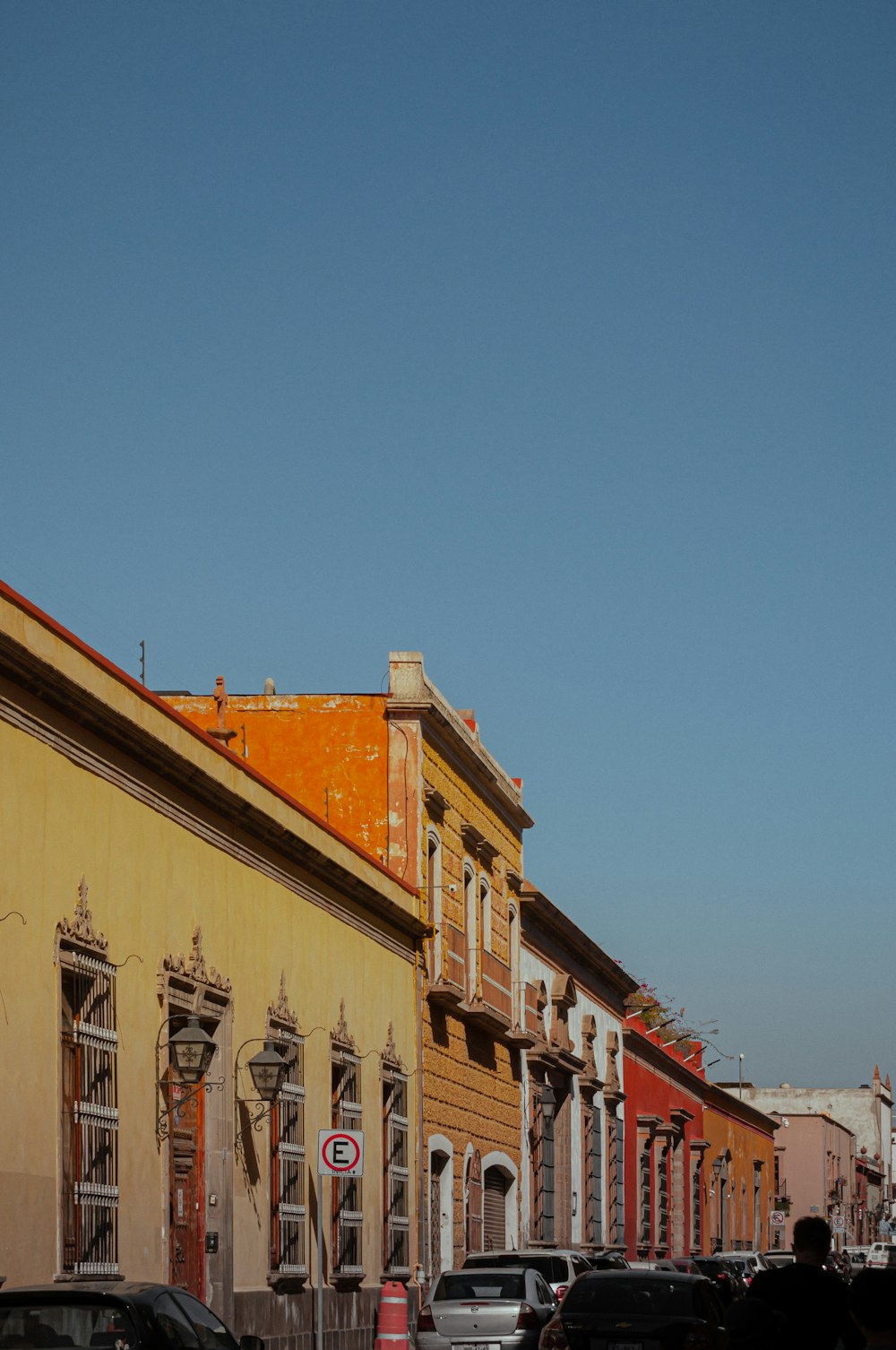 a row of buildings with cars parked on the side of the street