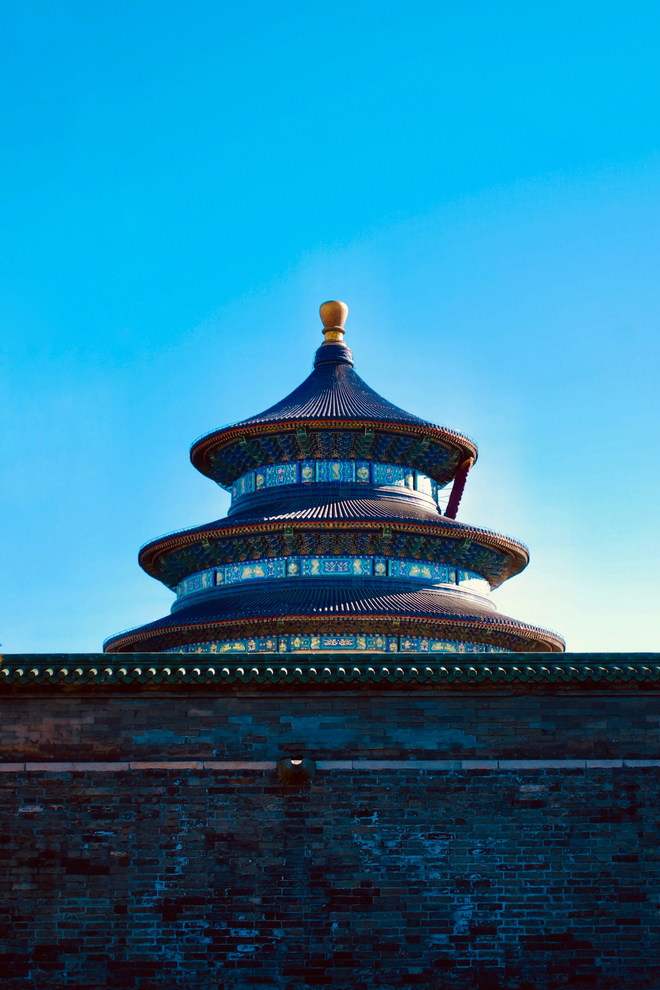 a tall blue building sitting on top of a brick wall
