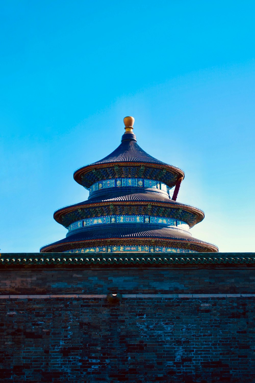 a tall blue building sitting on top of a brick wall