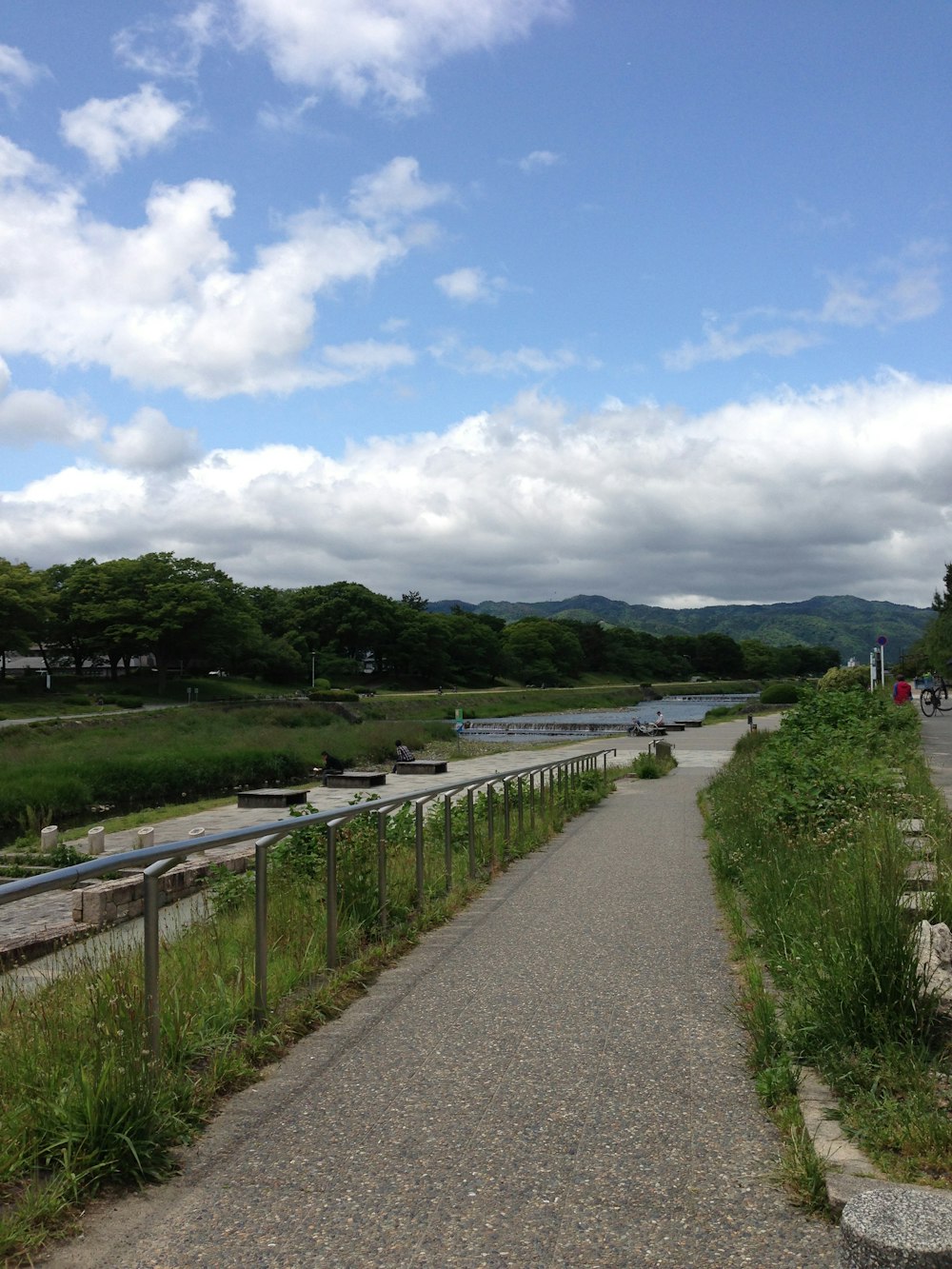 a paved path next to a body of water