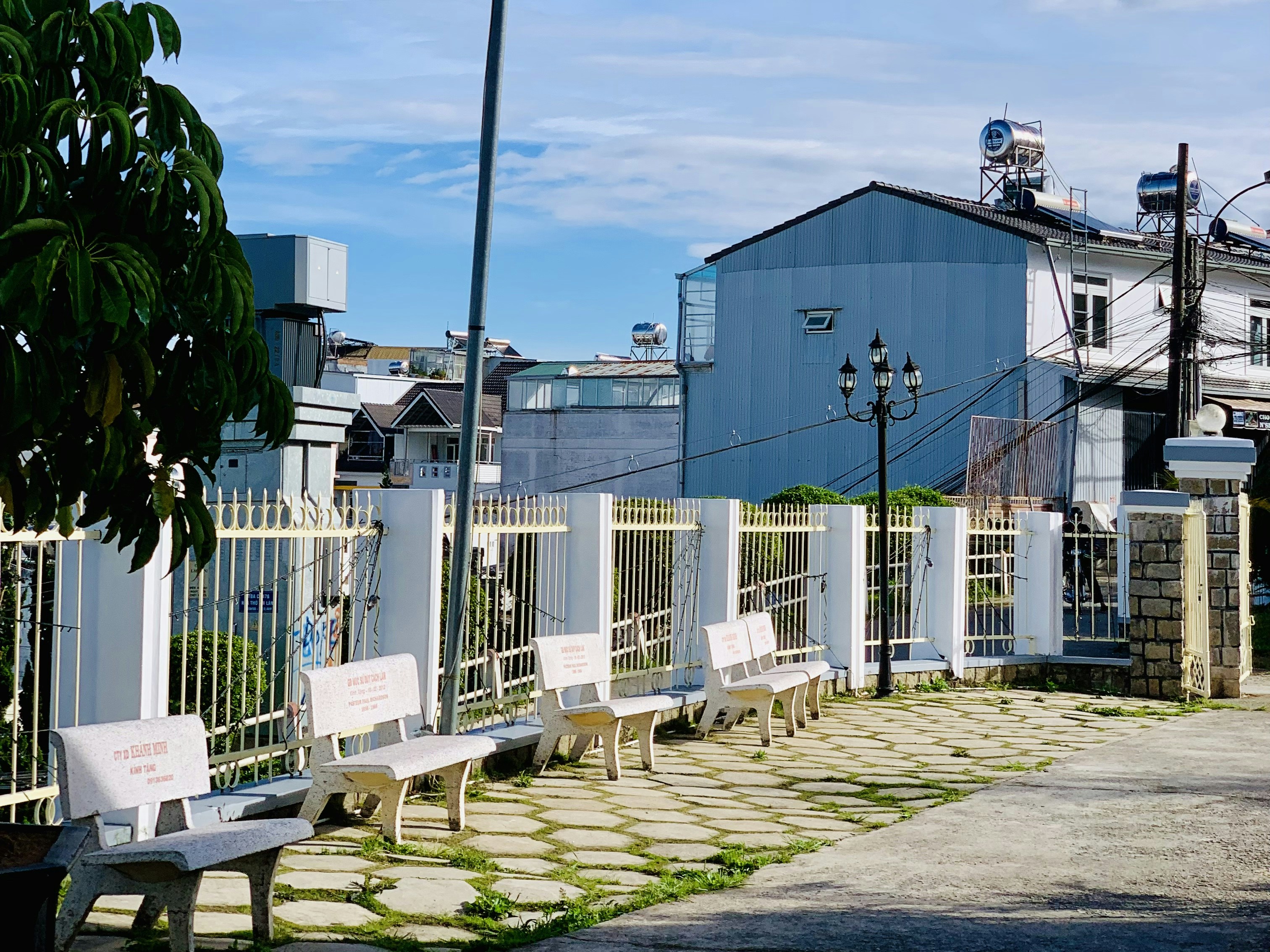 a row of benches sitting next to a white fence
