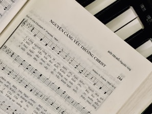 Sheet music featuring a hymn titled 'NGUYỆN CÀNG YÊU THƯƠNG CHRIST' with lyrics in Vietnamese. The page includes music notes, staff, and lyrics, suggesting a religious song. On the right side, a piano keyboard is partially visible.