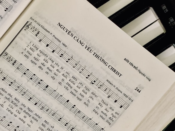 Sheet music featuring a hymn titled 'NGUYỆN C&Agrave;NG Y&Ecirc;U THƯƠNG CHRIST' with lyrics in Vietnamese. The page includes music notes, staff, and lyrics, suggesting a religious song. On the right side, a piano keyboard is partially visible.