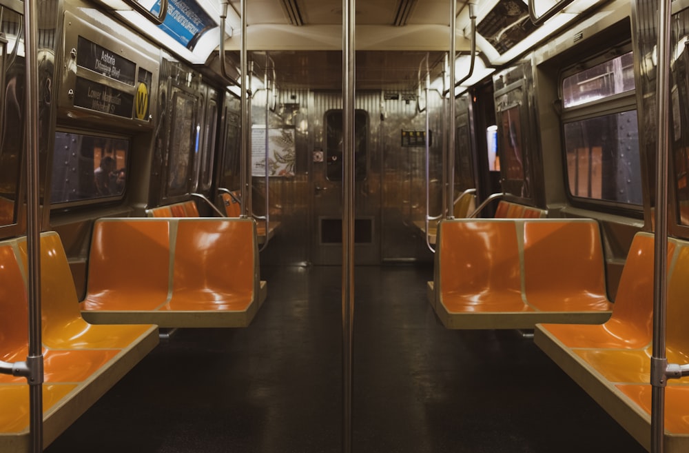 an empty train car with orange seats