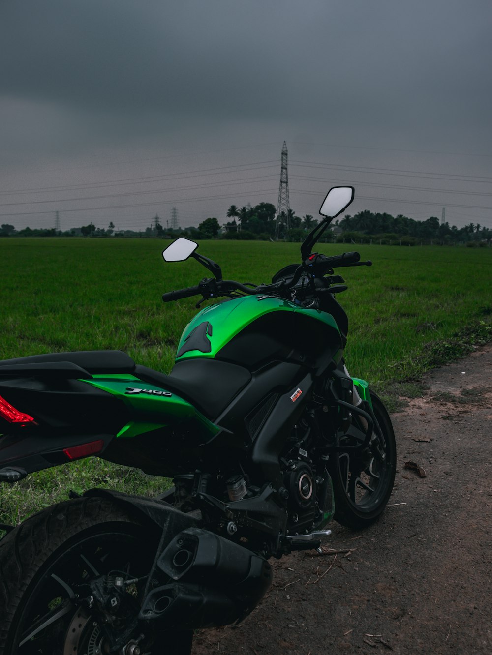 a green and black motorcycle parked on the side of a road