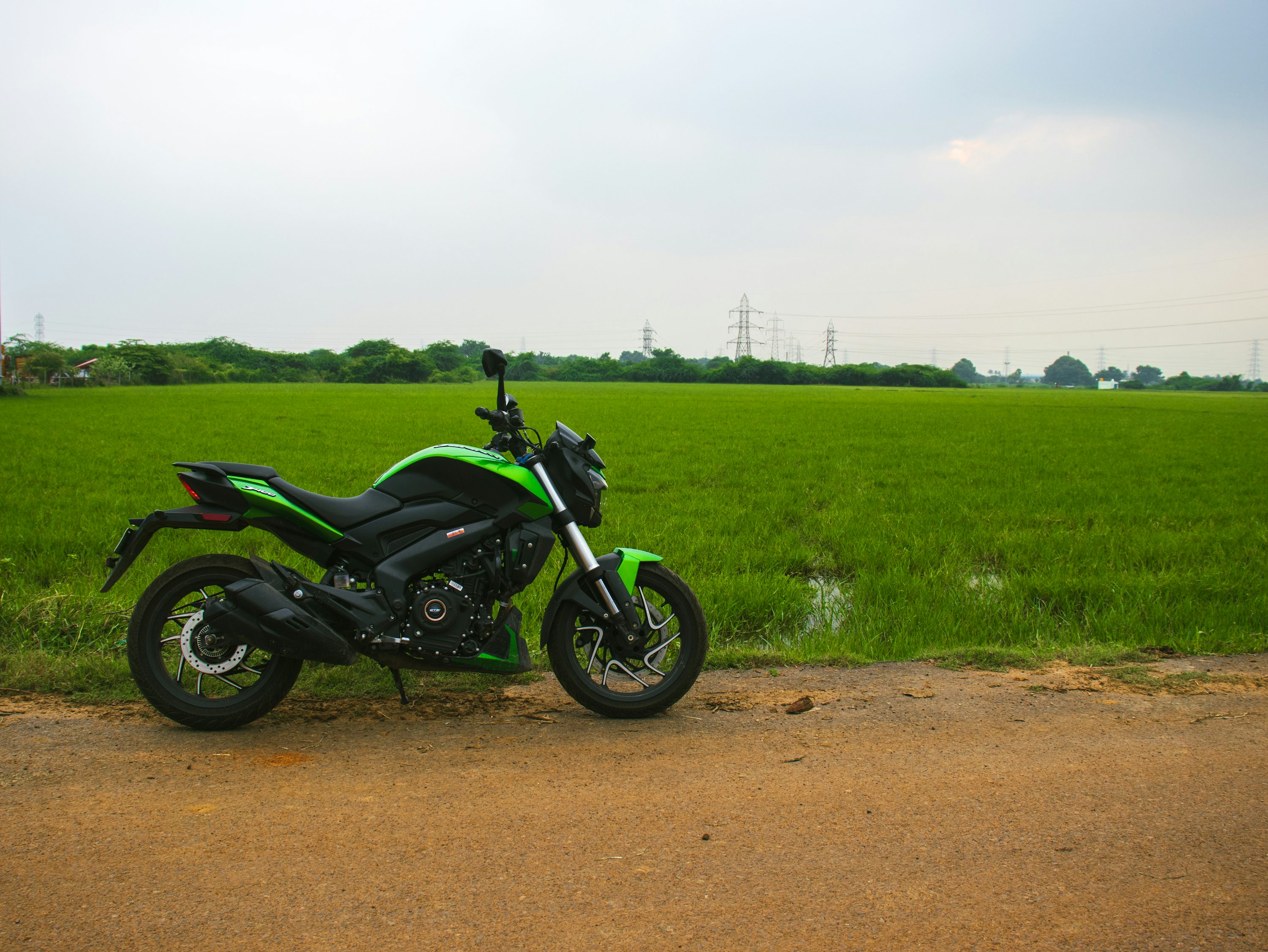 a motorcycle parked on the side of a dirt road