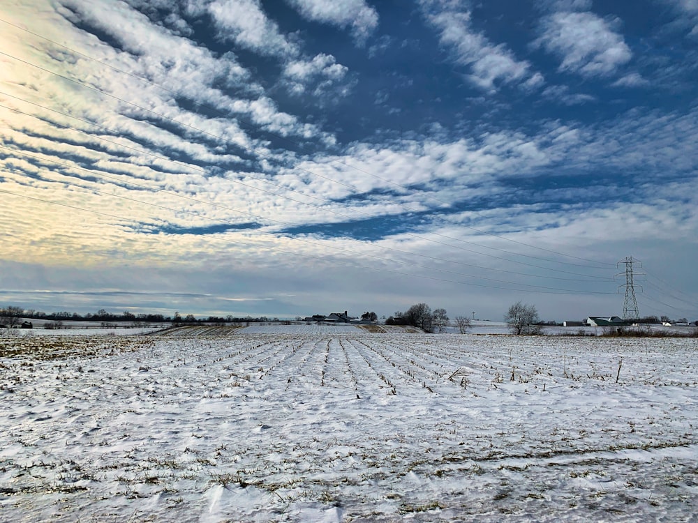 a snow covered field with power lines in the distance