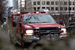 a red fire truck driving down a street next to tall buildings