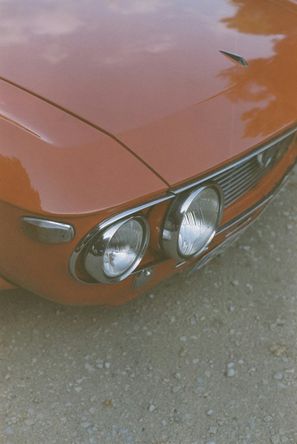 a close up of the front of an orange car