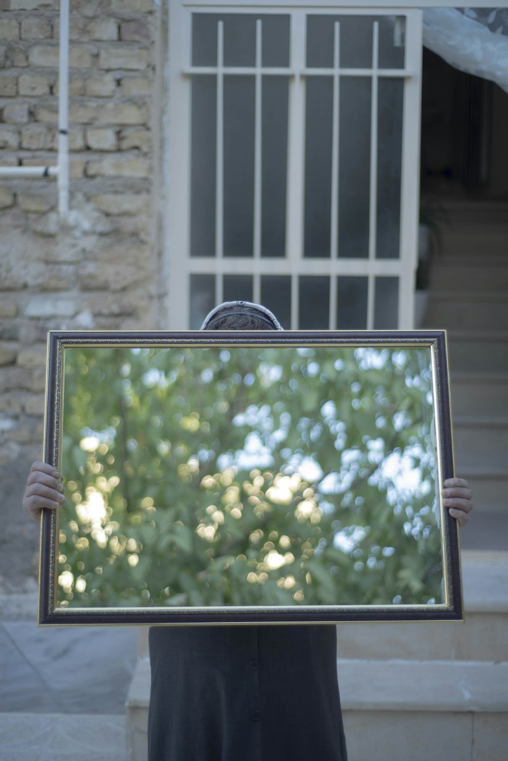 a person holding a mirror in front of their face