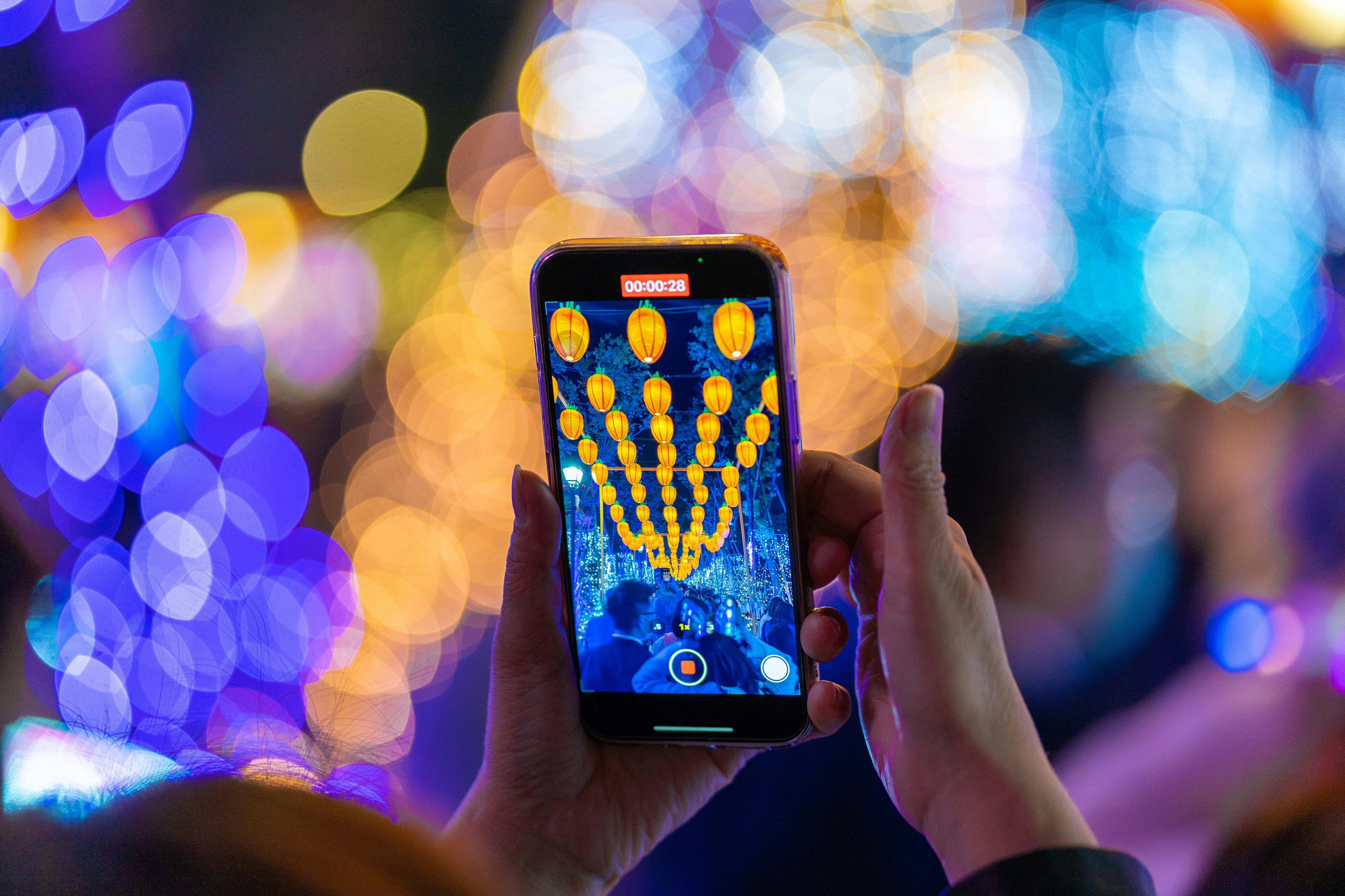 a person holding up a cell phone in front of a blurry background