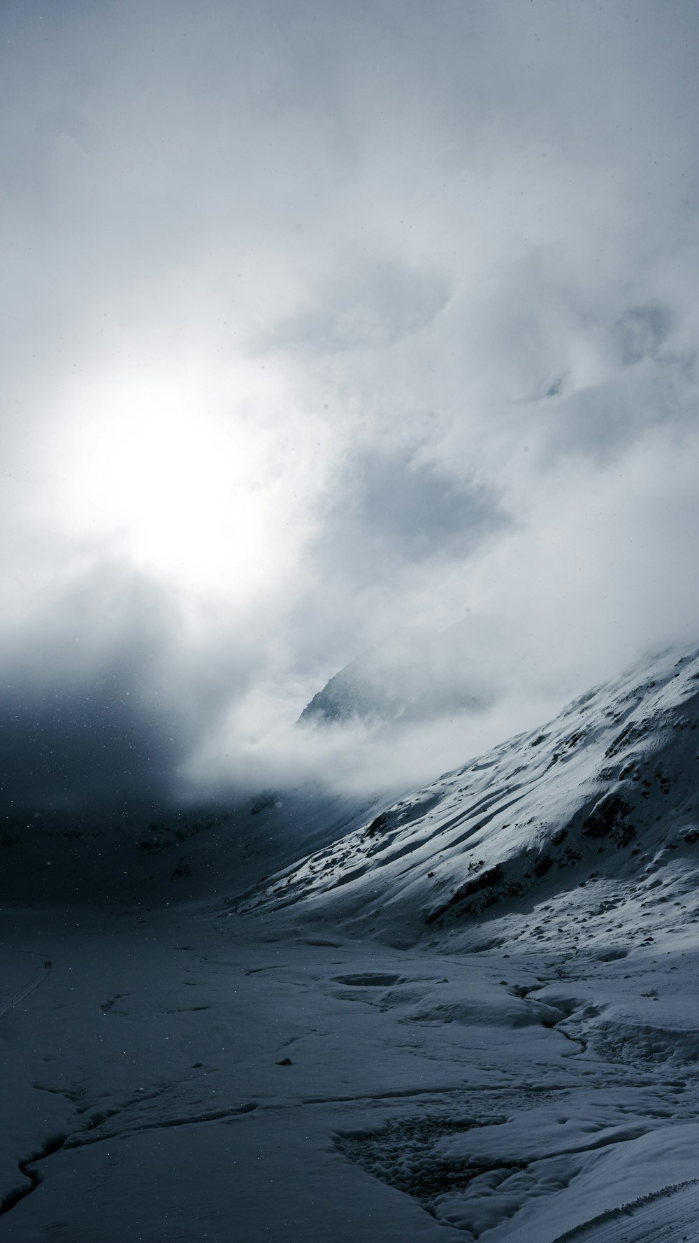 a mountain covered in snow under a cloudy sky