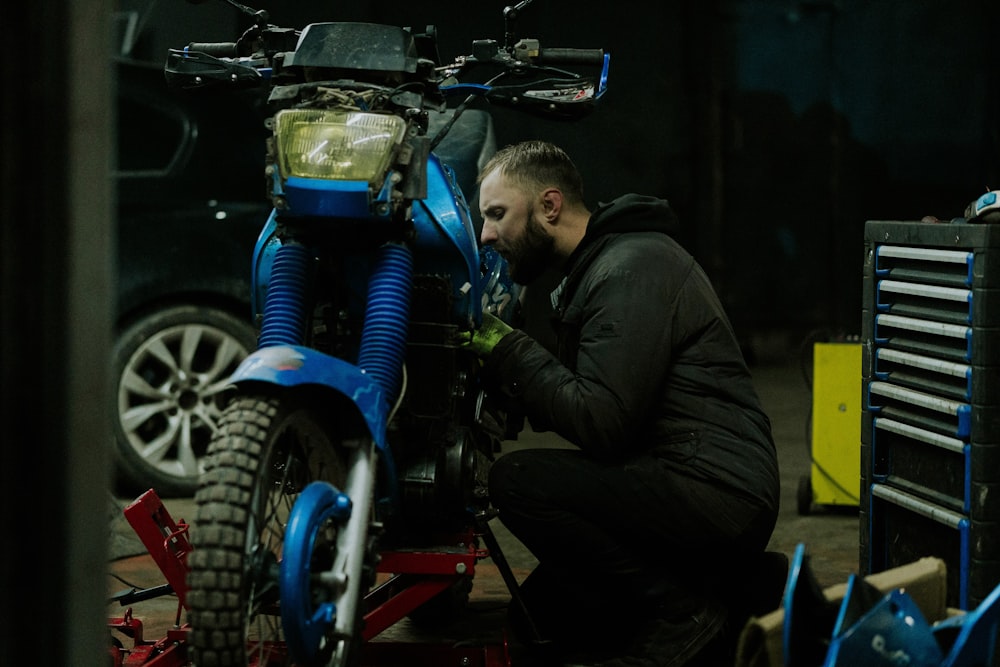 a man working on a motorcycle in a garage