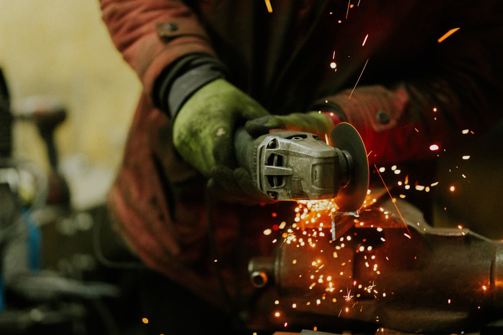 a person using a grinder on a piece of metal