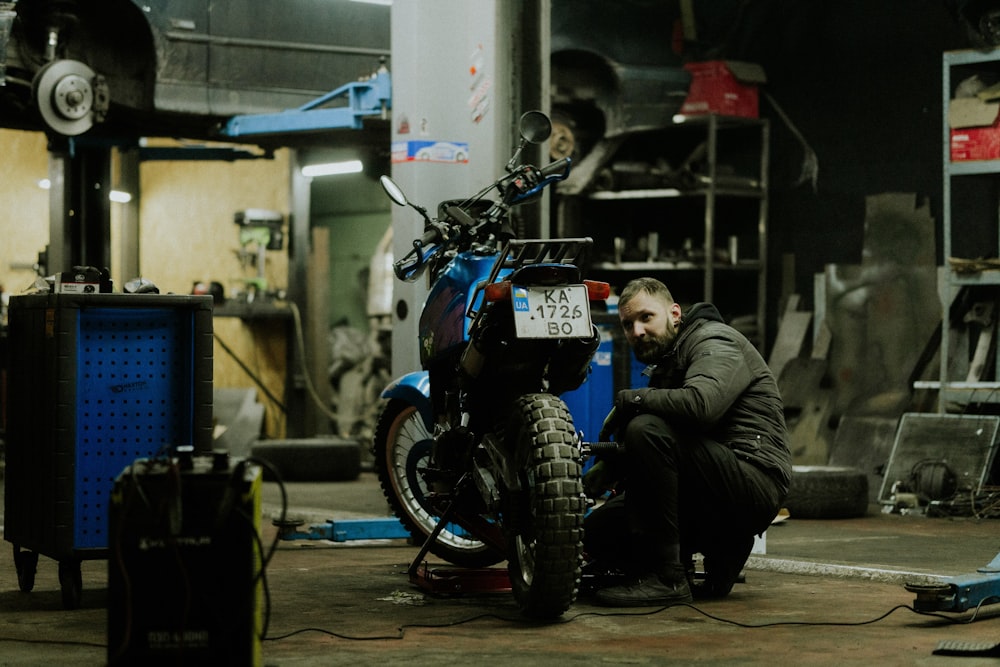 a man working on a motorcycle in a garage