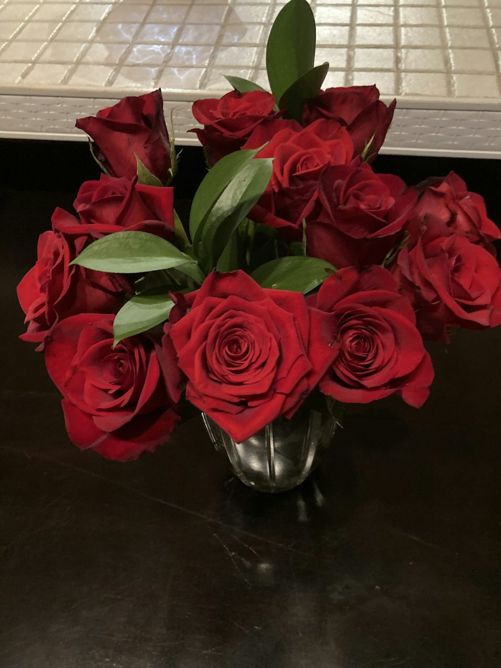 a vase filled with red roses on top of a table