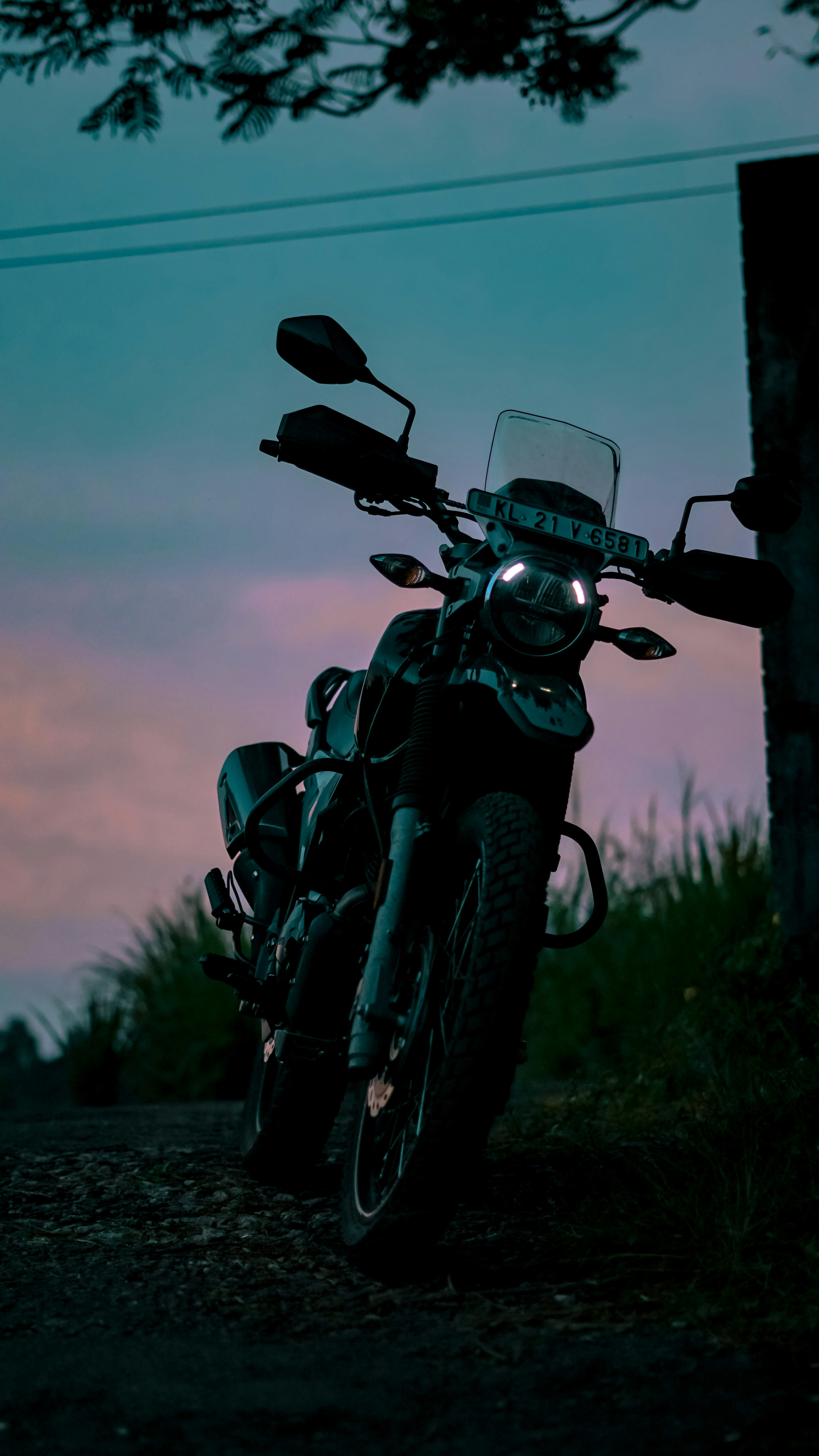 Texas highway at dusk with vast open skies, orange and purple sunset, flat terrain with scattered scrub brush, lone motorcycle silhouette on road, cinematic wide shot