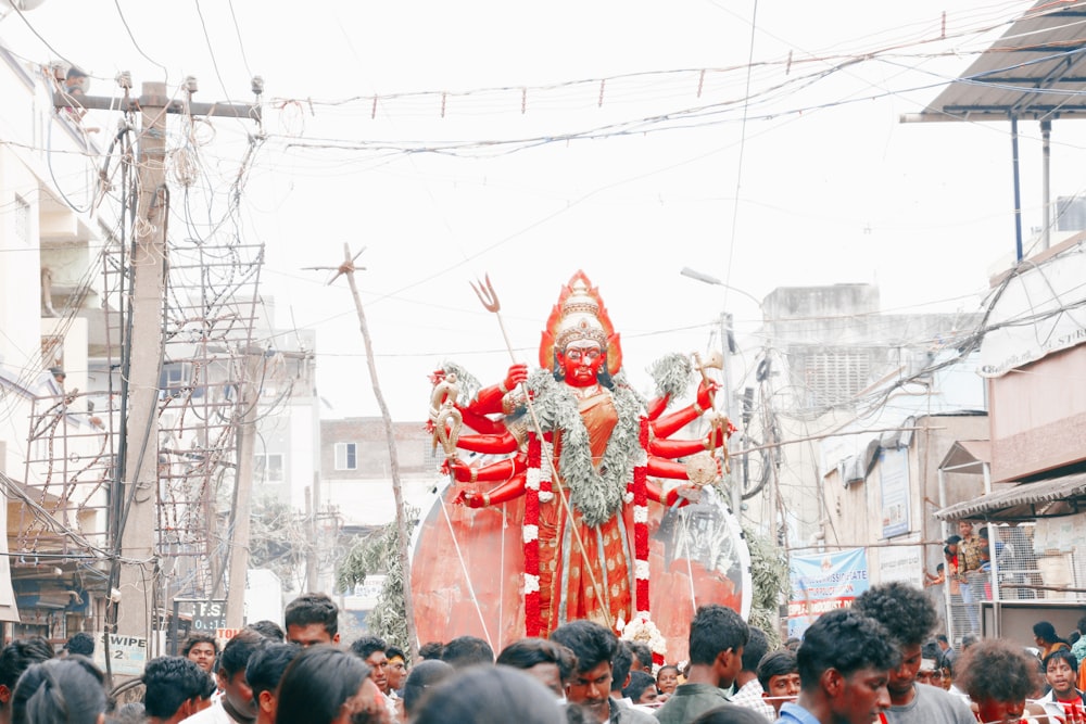 a large statue of a god in a crowded street