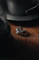 Close-up of a handcrafted coin ring resting on a wooden surface.