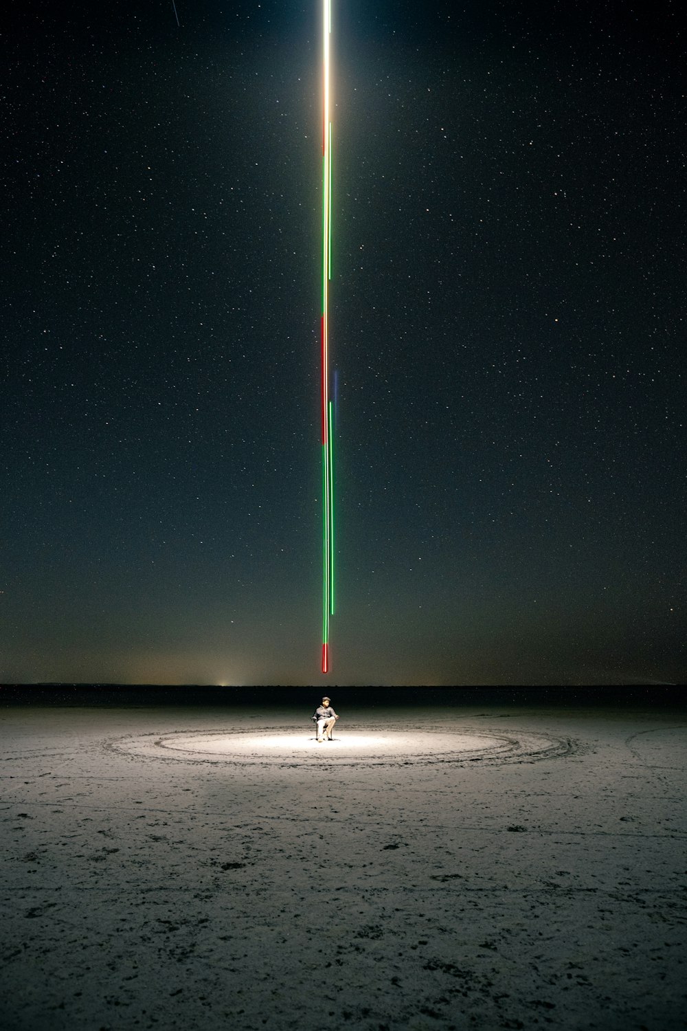 a person standing in the middle of a field under a star filled sky