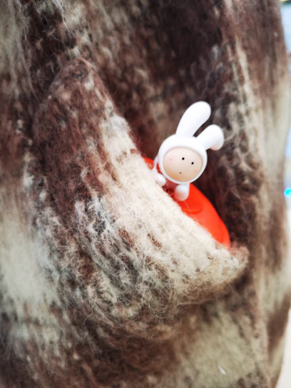 A close-up of a soft cotton tee featuring a playful rabbit graphic wearing a hard hat, set against a rustic wooden background.