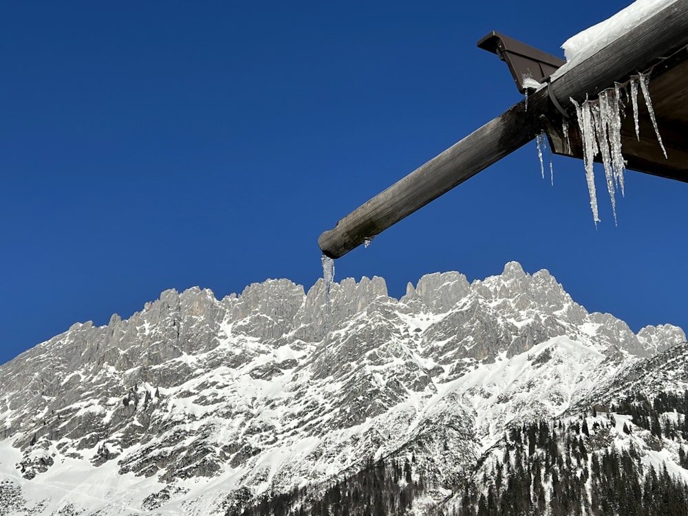 icicles hang from the roof of a building in front of a mountain