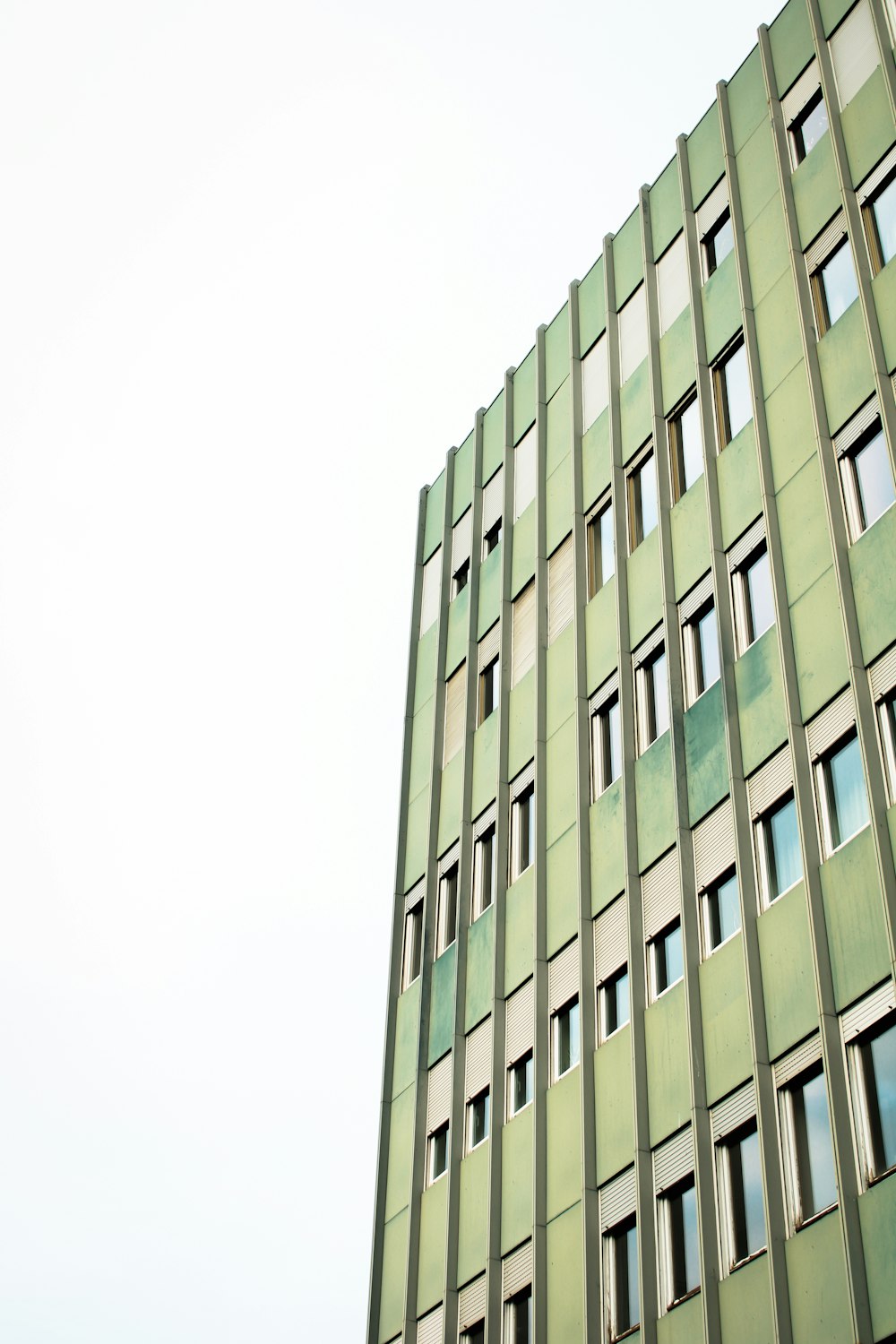 Ein hohes grünes Gebäude mit vielen Fenstern