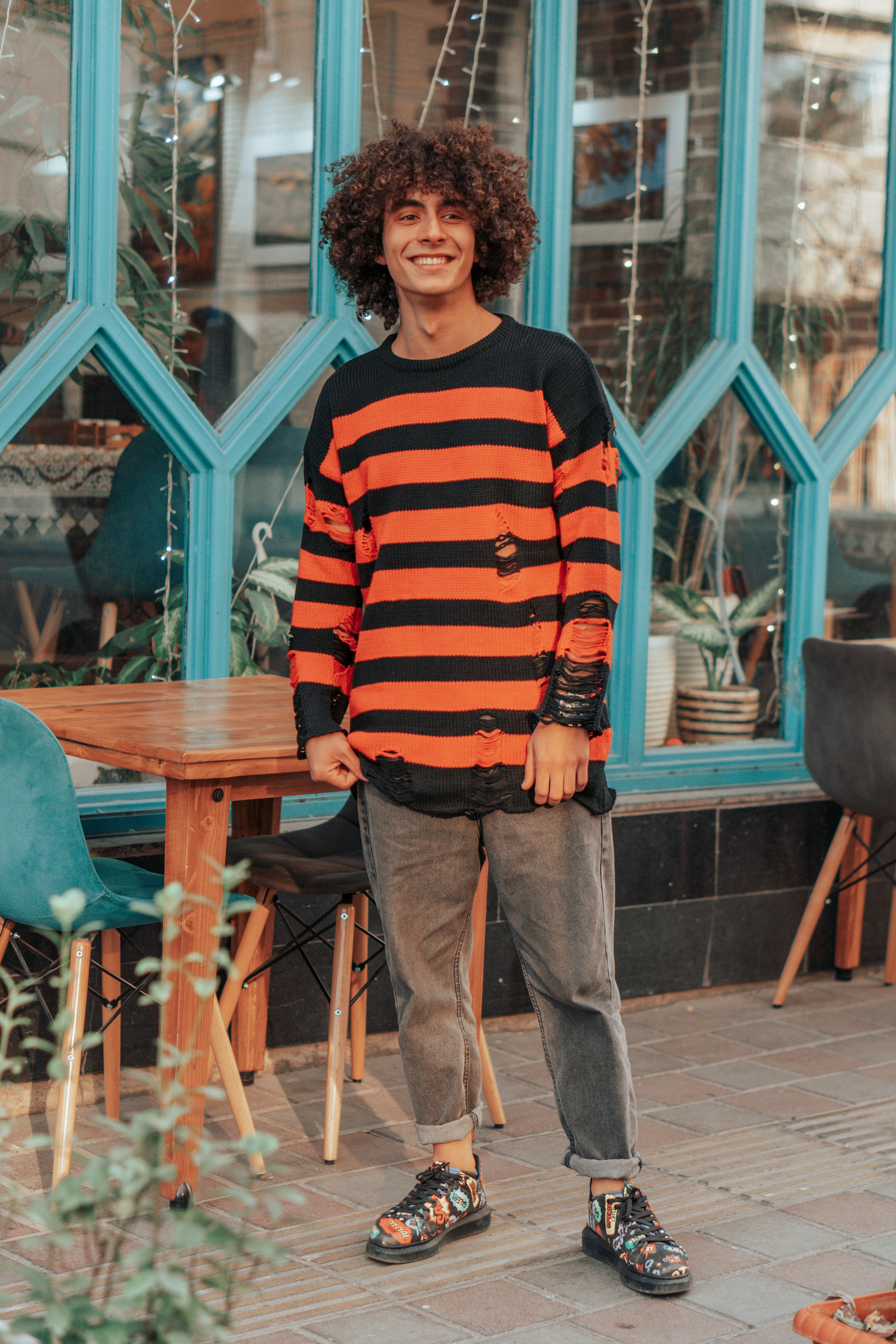 A young man standing in front of a store