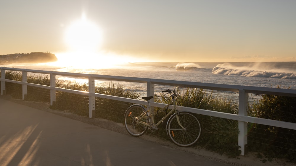 a bike parked on the side of a road next to the ocean