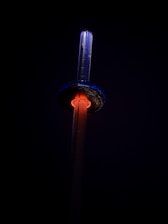 A sleek modern telecom tower with glowing blue and purple accents against a light background.