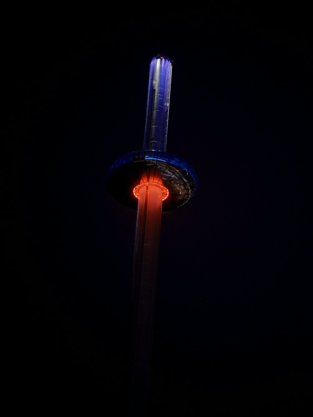 a street light in the dark with a red light on it