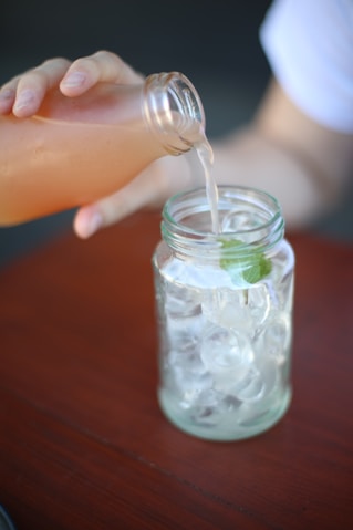 a person pours water into a jar filled with ice