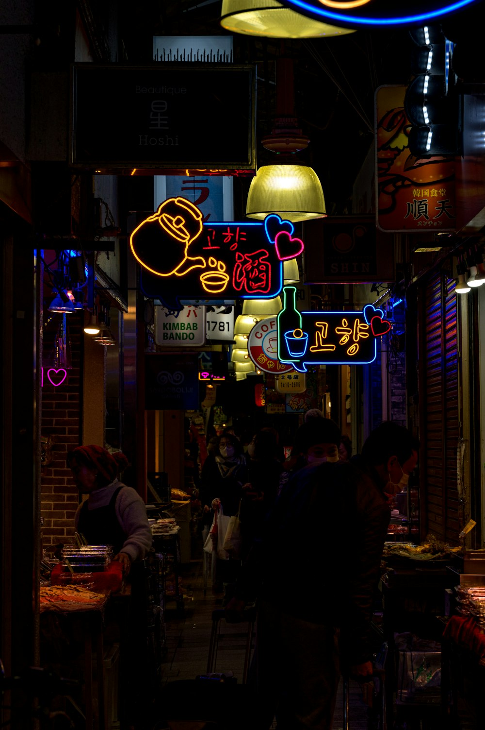 a group of people walking down a street at night