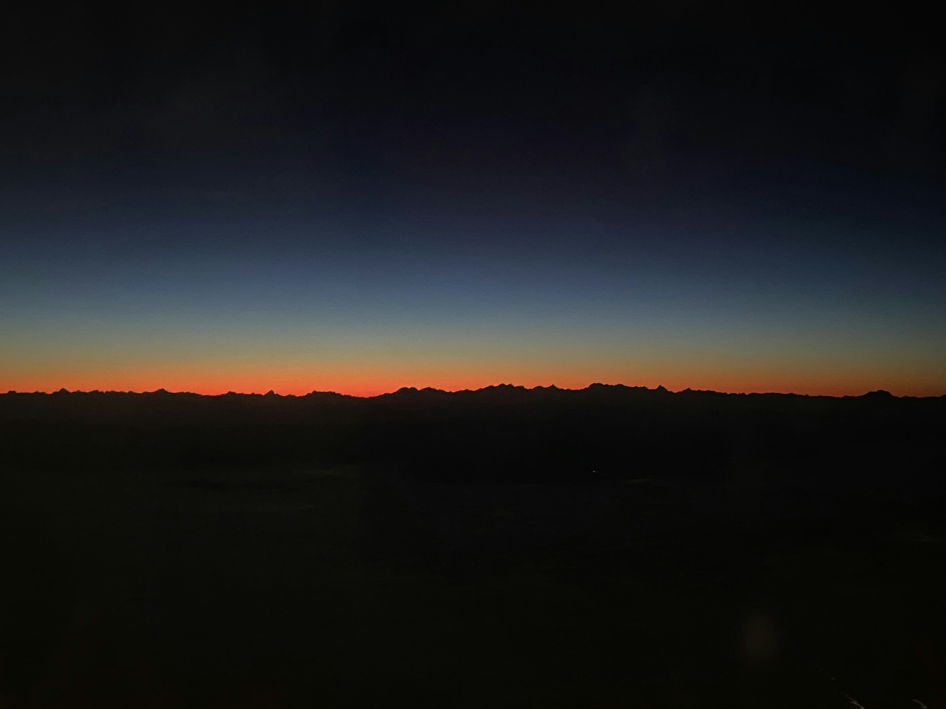 the sun is setting over a mountain range