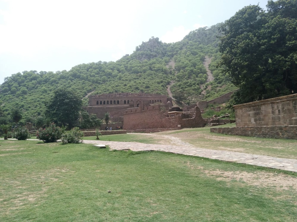 a large building sitting on top of a lush green hillside