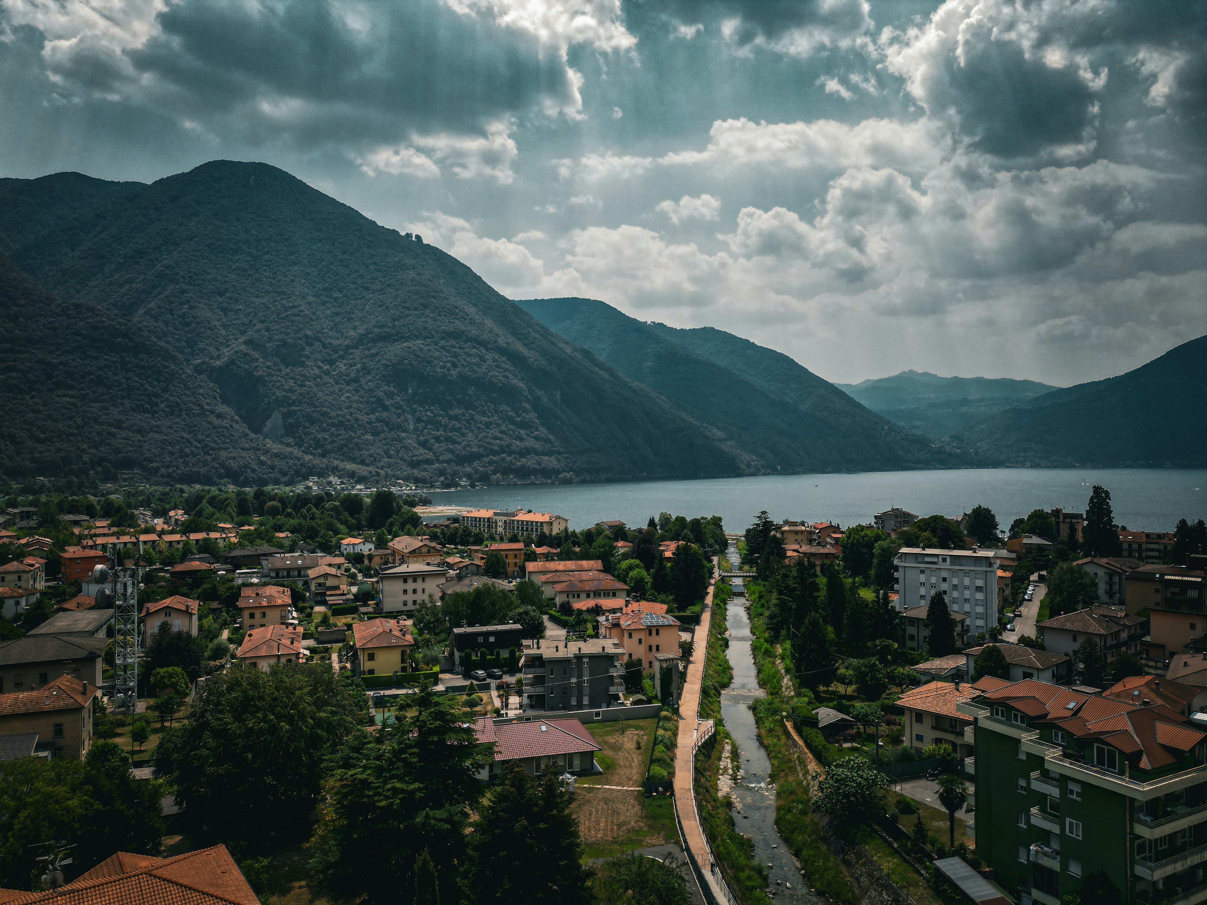 a scenic view of a town with mountains in the background