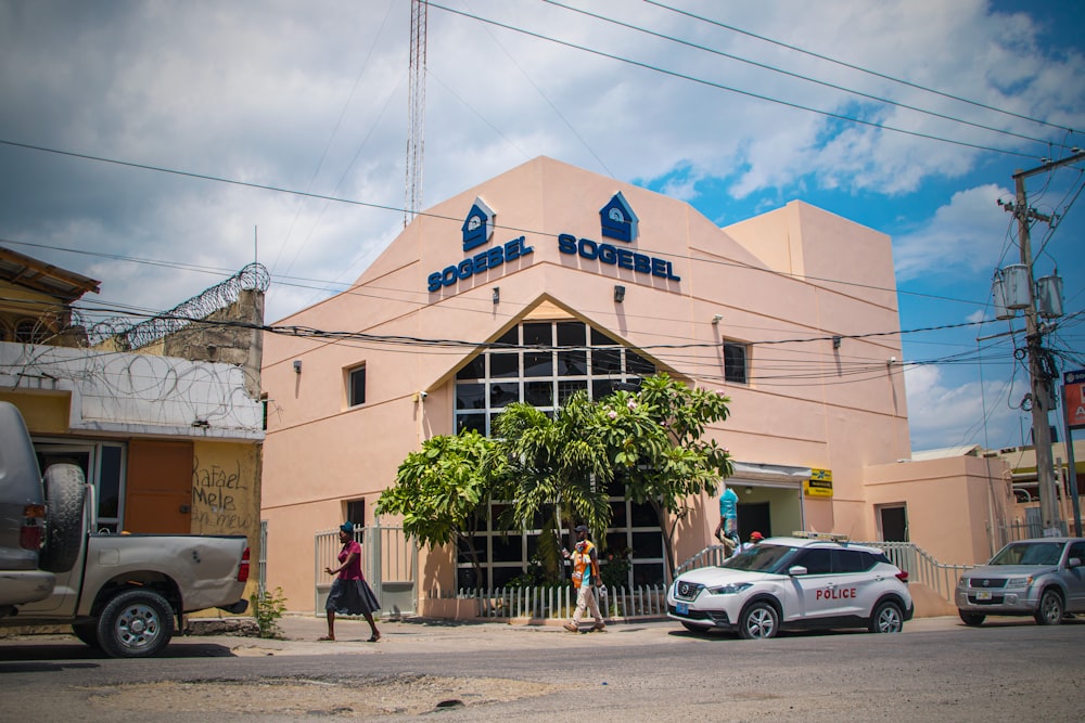 a car parked in front of a pink building